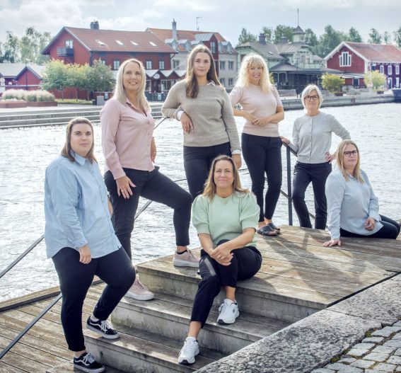 Medarbetare från Talenoms kontor i Nyköping samlade vid vattnet i centrala stan. Gruppen poserar framför klassiska trähus i en trivsam miljö.