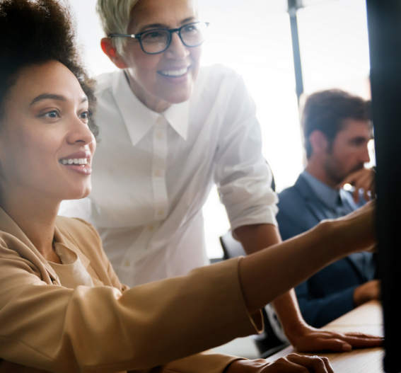 Kollegor arbetar tillsammans vid skärm på kontor, som visar samarbete, rådgivning och helhet inom redovisning och ekonomi.